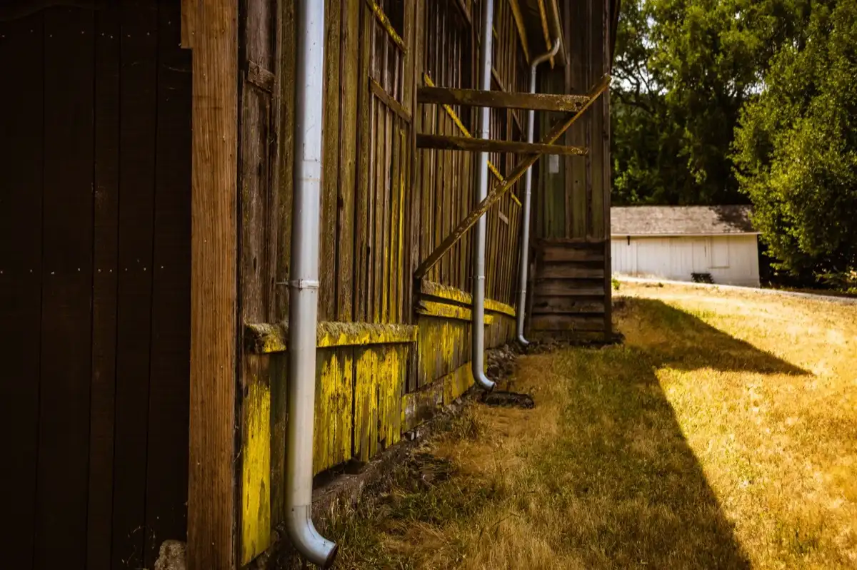 Roof edge, fascia and downspout on a house in Savannah, GA, where drip edge carries runoff into the gutter